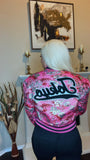 Model wearing a Next Level Varsity Jacket from Keeping It Posh Boutique - Back View